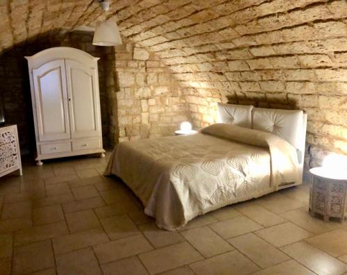 una camera con letto e parete in pietra di Dimora Pietra Antica a Bari