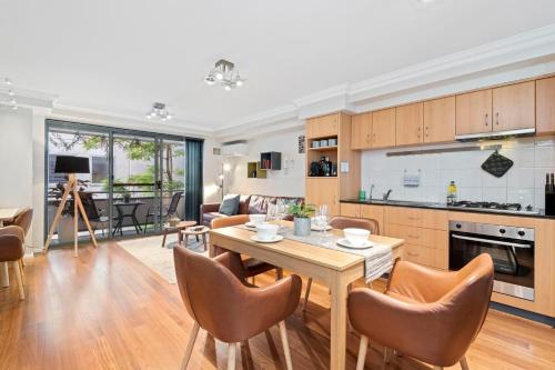 uma cozinha e sala de estar com mesa e cadeiras em 2 Royal Rest Quality 2br West Perth-parking em Perth