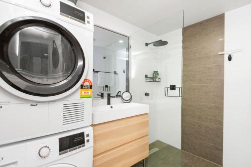 een badkamer met een wasmachine en een wastafel bij 2 Royal Rest Quality 2br West Perth-parking in Perth