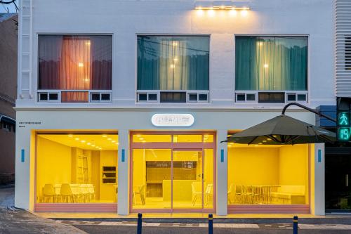 a building with yellow doors with tables and chairs at Shourin Hotel Daejeon by Aank in Daejeon