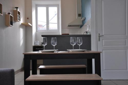 uma cozinha com uma mesa com copos de vinho em nid douillet 4places 2lits cœur de ville logement Hote-Zen wifi em Segré