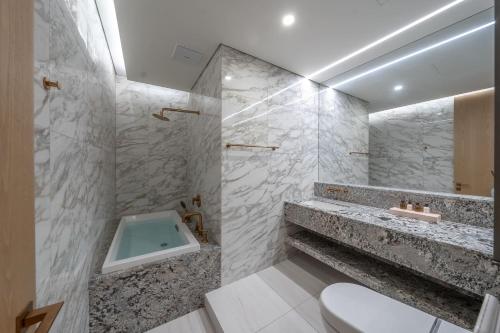 ein Badezimmer mit einer Badewanne, einem WC und einem Waschbecken in der Unterkunft Busan Station BOOKING THE BAY in Busan