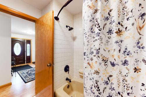 a bathroom with a shower with a blue and white shower curtain at Neverending Lake Fun in Paris