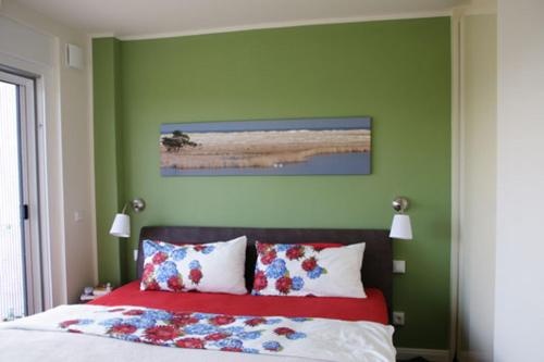 - une chambre verte avec un lit fleuri dans l'établissement Käptn Brass Appartement 23 Düne 10, à Dierhagen