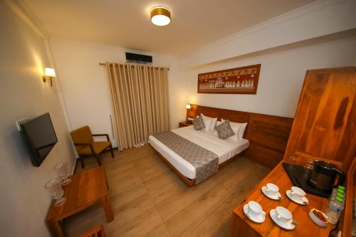 a small hotel room with a bed and a table at BPR - Asgiriya ,Kandy in Kandy