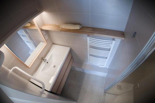 a small bathroom with a sink and a mirror at L'ODYSSÉE BLEUE VUE MER in Cassis