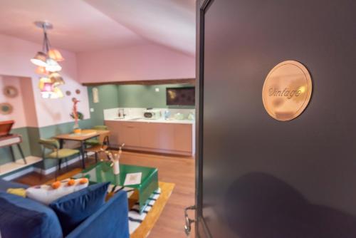 un salon avec un canapé bleu et une cuisine dans l'établissement Le vintage . Centre-ville Mâcon . Atypique . Proche gare . Wifi . Climatisation . Confortable ., à Mâcon