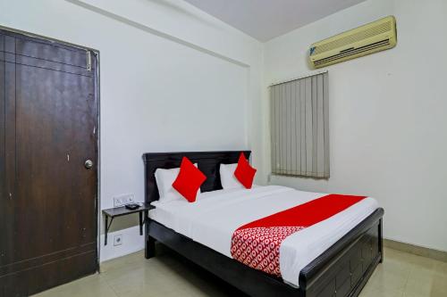 a bedroom with a bed with red pillows at OYO Rs Hotel Near Hitech City in Kondapur
