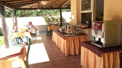 Dos personas están sentadas en mesas en un restaurante en Hotel Anselmi, en Marciana Marina