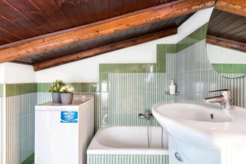 a bathroom with a tub and a sink at Casa Bastione Taormina in Taormina
