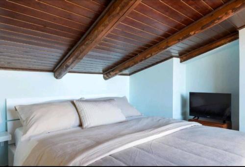 a bedroom with a bed and a flat screen tv at Casa Bastione Taormina in Taormina