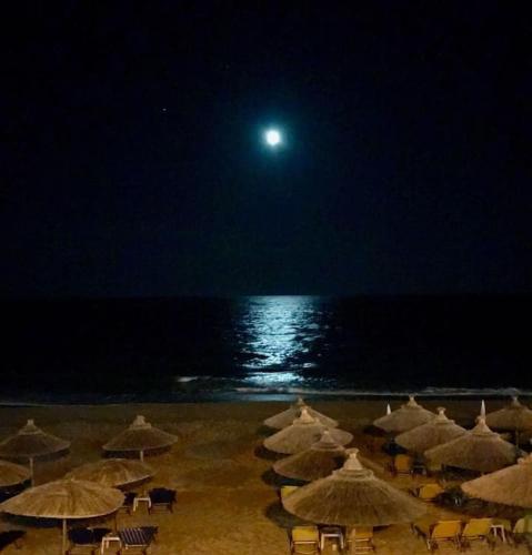 a group of umbrellas on the beach at night at LEMONELIA, one big,4-5 people and one small apartment ,2-3 people in Loutsa