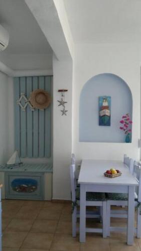 a dining room with a white table and chairs at LEMONELIA, one big,4-5 people and one small apartment ,2-3 people in Loutsa