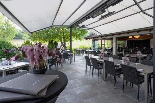 ein Restaurant mit Tischen und Stühlen und eine Terrasse in der Unterkunft Hotel Restaurant Zehn-Brunnen in Renningen