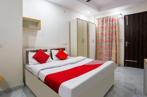 a bedroom with a bed with red pillows at OYO Flagship 78640 Hotel J Inn in New Delhi