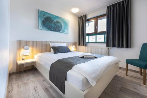 1 dormitorio con 1 cama grande y 1 silla azul en Hotel Restaurant Zehn-Brunnen en Renningen
