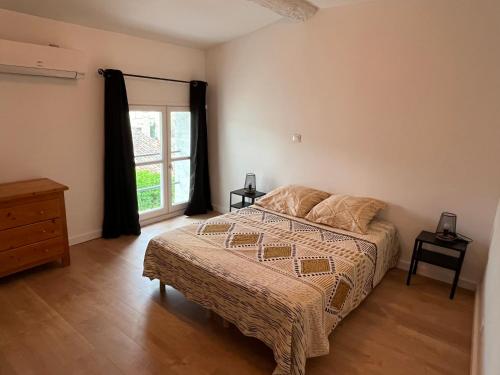 une chambre avec un grand lit et une fenêtre dans l'établissement Maison rénovée entre coeur de village et garrigue, à Saint-Martin-de-Londres