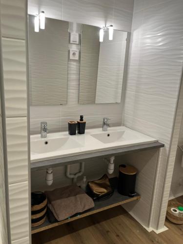 une salle de bain avec deux lavabos et un miroir dans l'établissement Maison rénovée entre coeur de village et garrigue, à Saint-Martin-de-Londres