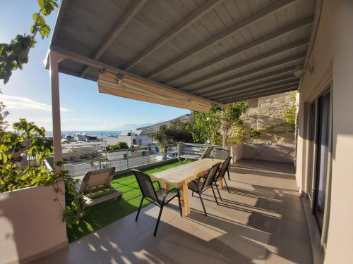 a patio with a wooden table and chairs on a balcony at Villa Dream in Matala