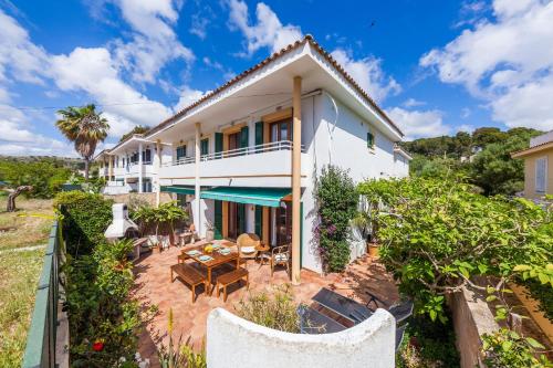 an exterior view of a house with a patio at Casa Ginebro in Font de Sa Cala