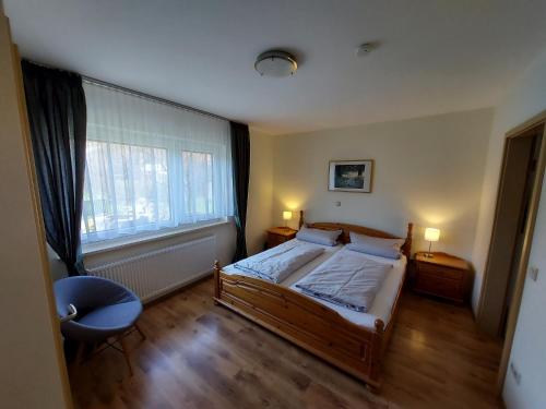 ein Schlafzimmer mit einem Bett und einem großen Fenster in der Unterkunft Ferienwohnung Wiesenschneider´s in Freiensteinau