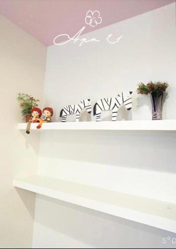 a white shelf with plants and vases on it at 吐司禾民宿 in Wujie