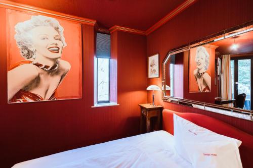 a red room with a bed and a mirror at Design Hotel Euskirchen in Euskirchen
