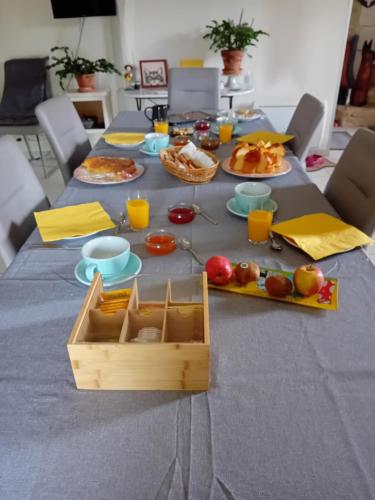 a table with plates of food and a box on it at Ode au Bonheur St Georges sur Cher in Saint-Georges-sur-Cher