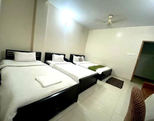 a room with two beds and a tv at Restinn Hotel in Maulvi Bāzār
