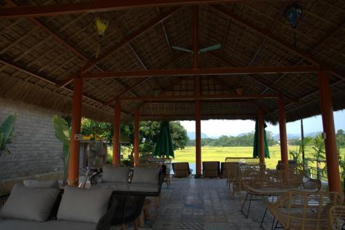 a pavilion at a resort with tables and chairs at Greenfield Ecostay in Phong Nha