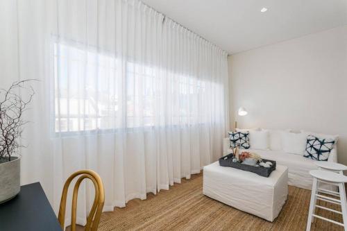 sala de estar con cortinas blancas y sofá blanco en Coogee Beach 2 Bedroom Apartment - CG226, en Sídney