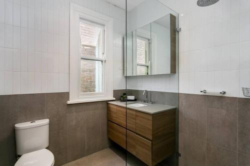 a bathroom with a toilet and a sink and a mirror at Coogee Beach 2 Bedroom Apartment - CG226 in Sydney