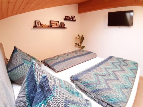 a room with two pillows on a bed with a tv at Haus Bacher Leogang in Leogang