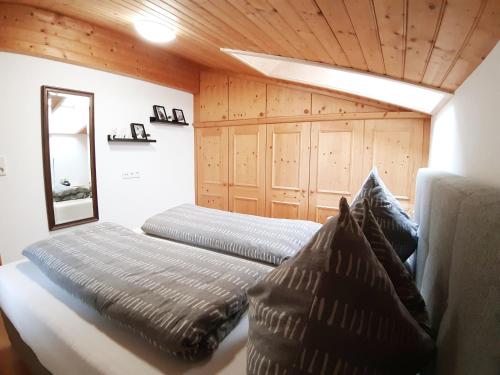 2 łóżka w pokoju z drewnianymi ścianami i sufitami w obiekcie Haus Bacher Leogang w mieście Leogang