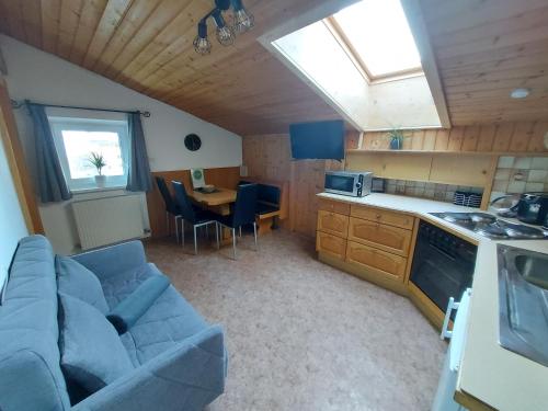 a living room with a couch and a kitchen with a table at Haus Bacher Leogang in Leogang