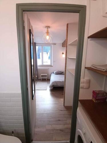 um corredor com uma porta que leva a um quarto com uma cama em Appart lumineux en centre-ville em Cherbourg en Cotentin