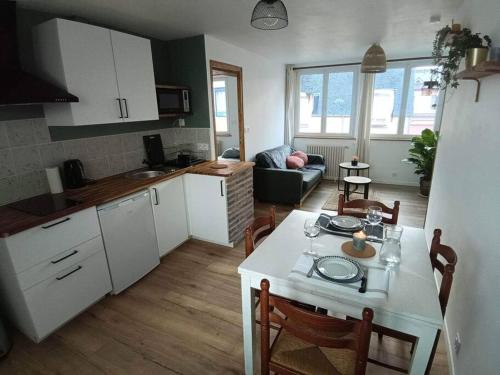 uma cozinha e uma sala de estar com mesa e cadeiras em Appart lumineux en centre-ville em Cherbourg en Cotentin