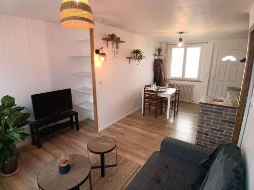 uma sala de estar com um sofá e uma mesa em Appart lumineux en centre-ville em Cherbourg en Cotentin