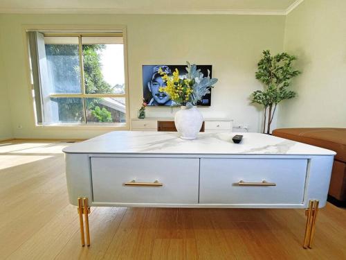 a white dresser with a vase of flowers in a room at Pet-Friendly Retreat 2BR Ringwood Prime location in Ringwood