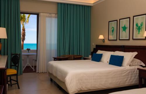 a bedroom with a bed and a view of the ocean at Hotel Schuhmann in Paestum