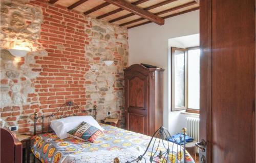 a bedroom with a bed and a brick wall at Gorgeous Apartment In Montefortino With Wifi in Montefortino
