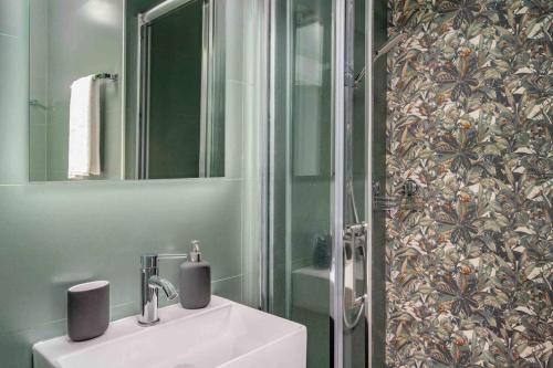 een badkamer met een wastafel, een spiegel en een douche bij Top výhledy, vyhřívaný bazén, pár minut od všeho in Benalmádena
