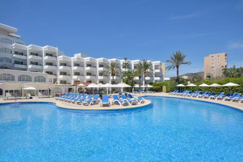 a pool with chairs and umbrellas in front of a hotel at Sol Lunamar Palmanova Apartamentos - Adults Only in Palmanova