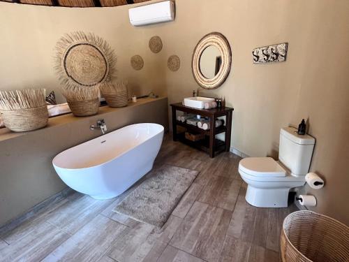 a bathroom with a white tub and a toilet at Die Boskamp Self-Catering Bush Retreat in Marble Hall
