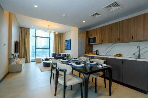 a kitchen and living room with a table and chairs at Charthouse Bahrain in Manama