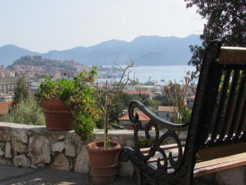 a bench sitting on a stone wall with potted plants at Appartamenti Bellavista - HelloElba in Portoferraio