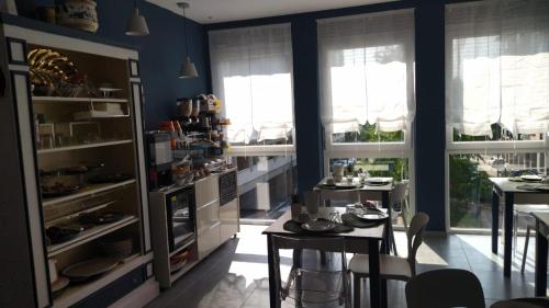 eine Küche mit blauen Wänden, einem Tisch und Fenstern in der Unterkunft Boutique Hotel Ferrara in Ferrara