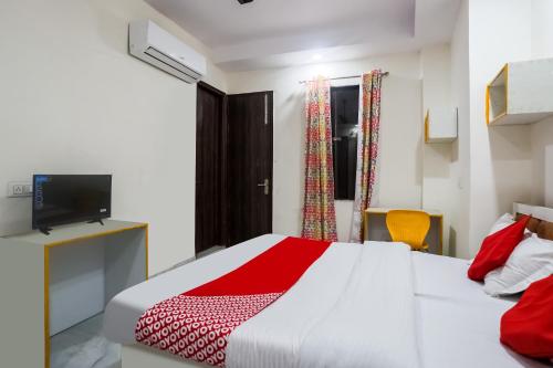 a bedroom with a white bed and a television at OYO Flagship 78640 Hotel J Inn in New Delhi