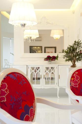 a living room with two red chairs and a white cabinet at Hotel Magic in Nazaré