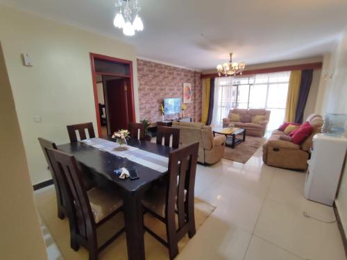 - une salle à manger et un salon avec une table et des chaises dans l'établissement Lux Suites Skyhorse Apartments Kilimani, à Nairobi